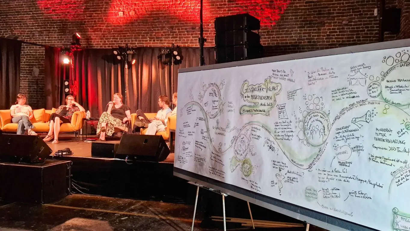 Graphic recording panel beside a stage during an evening event