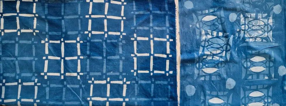 Indigo-dyed katazome textile by Katy Fox with stencilled grid and fish patterns